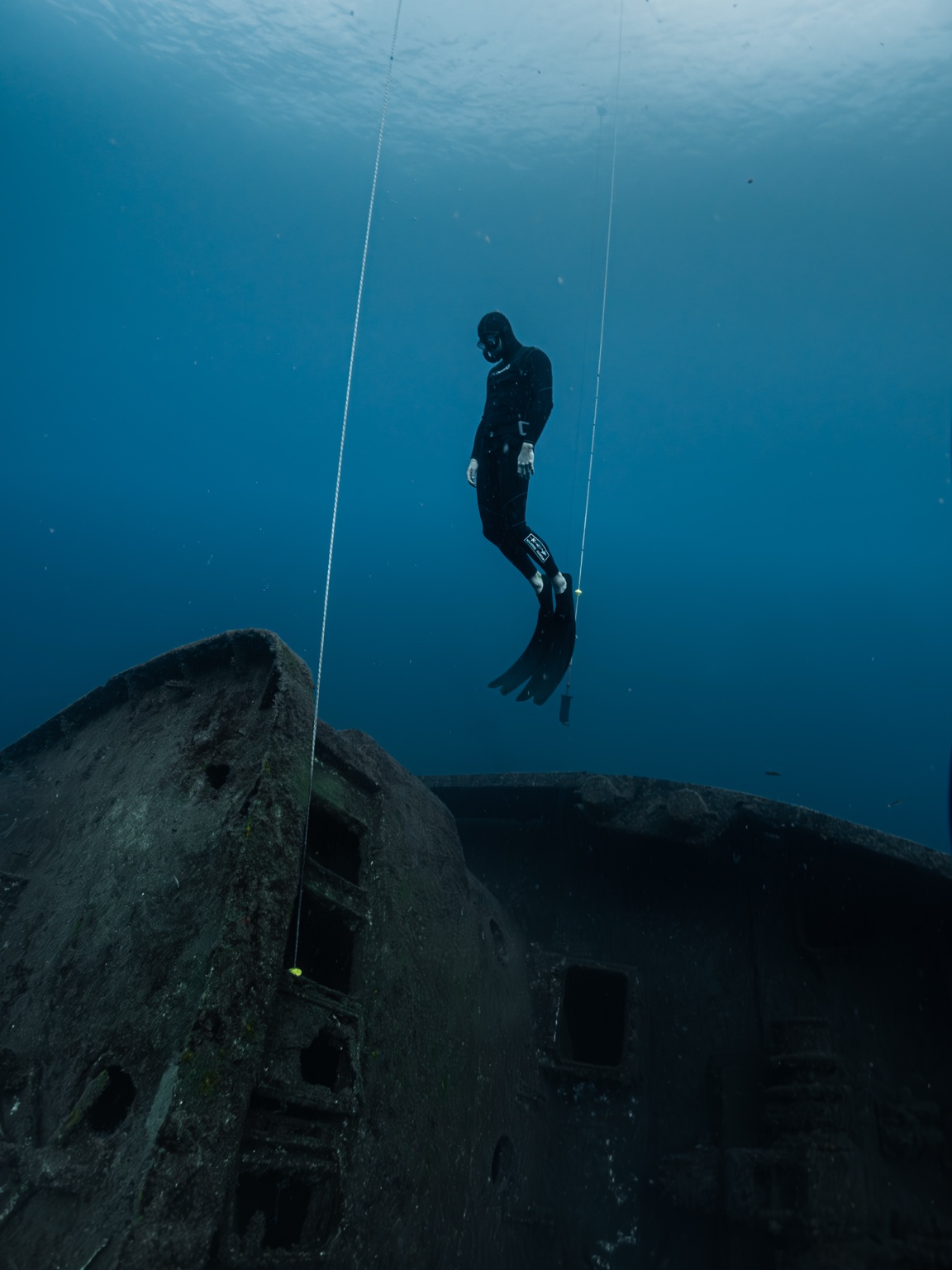 Freediver hovering above a shipwreck
